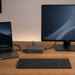 Portátil conectado a una docking station con monitor externo, teclado y ratón inalámbricos en un escritorio moderno.